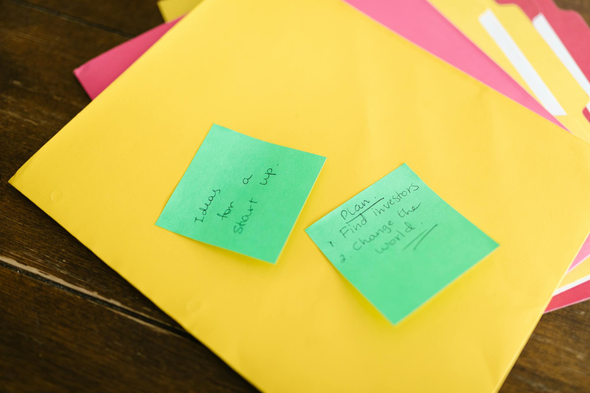 Vibrant sticky notes with startup ideas and plans placed on a desk.